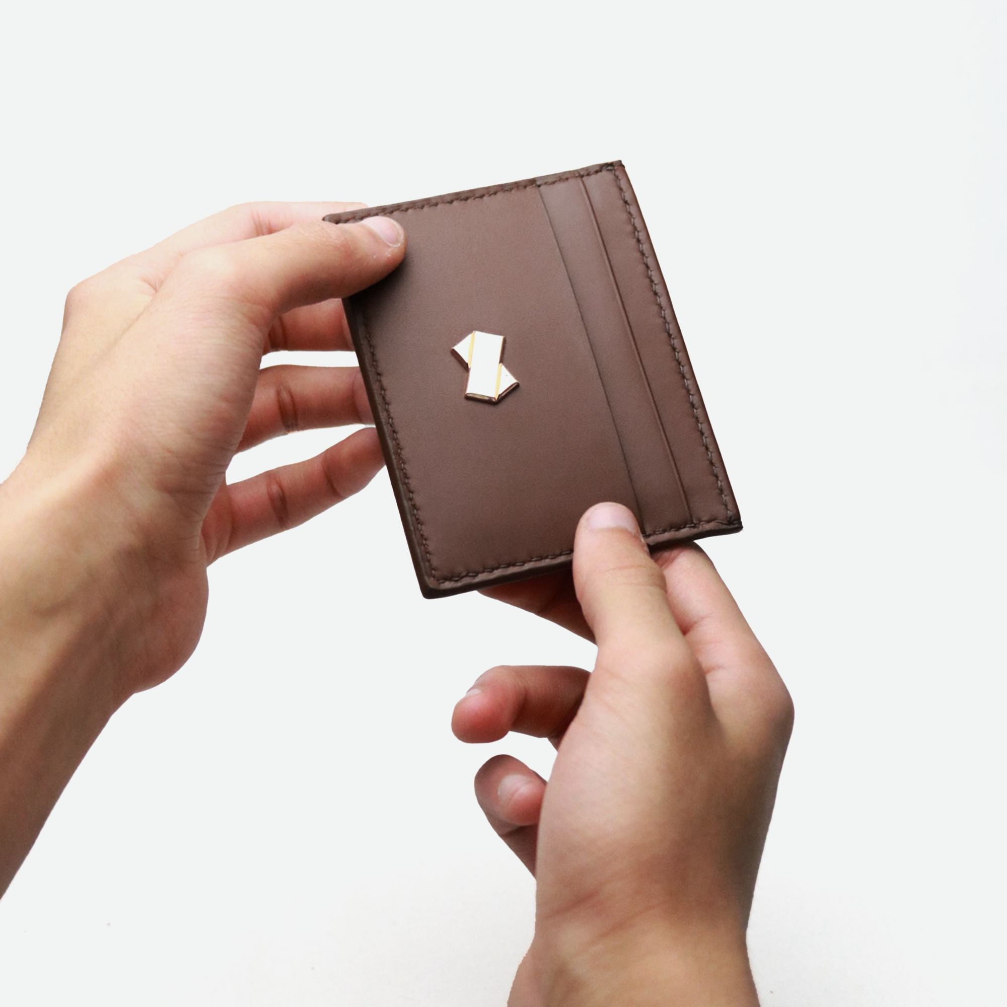 Brun læder kortholder Faubret i hånden med gyldent logo