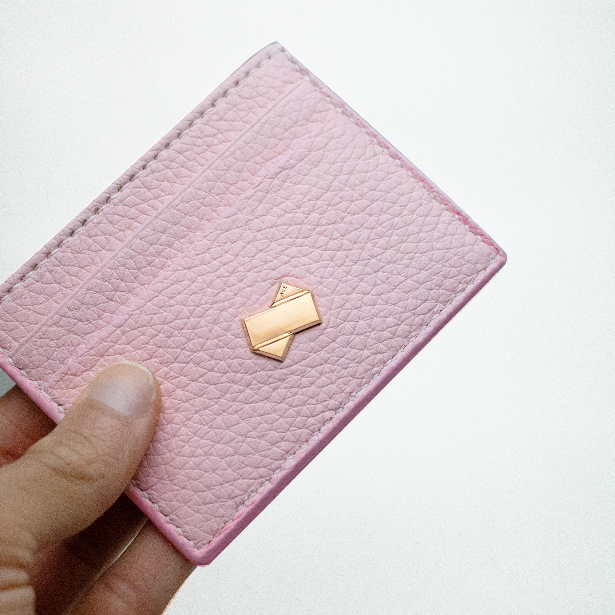 Kortholder til kvinder i lyserødt tyr-læder med forgyldt Faubret-logo.