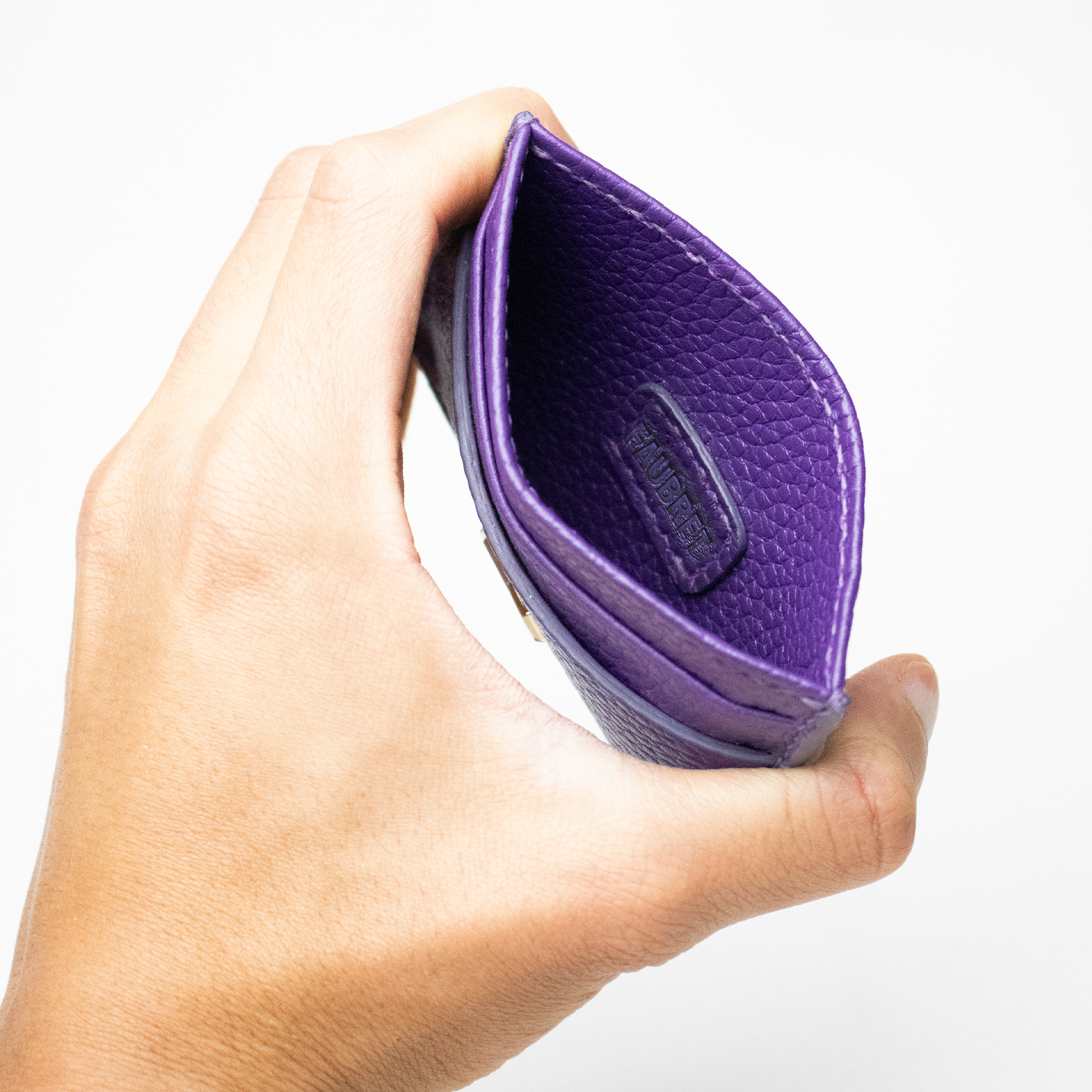 Indersiden af Faubret lilla læder kortholder med præget logo og håndlavet finish.