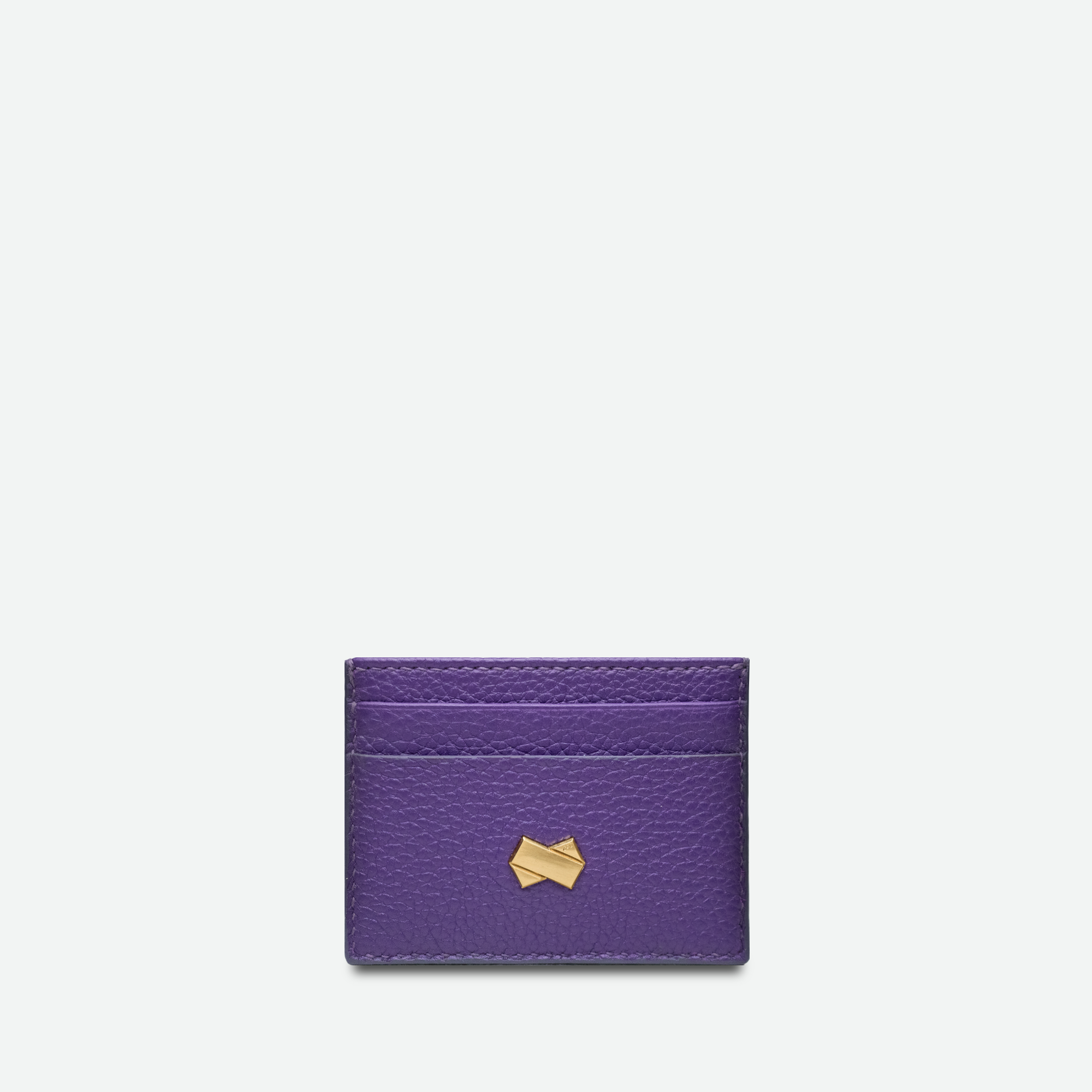 Kortholder til kvinder i lilla præget læder med gyldent Faubret-logo. Fransk elegance og håndværk.