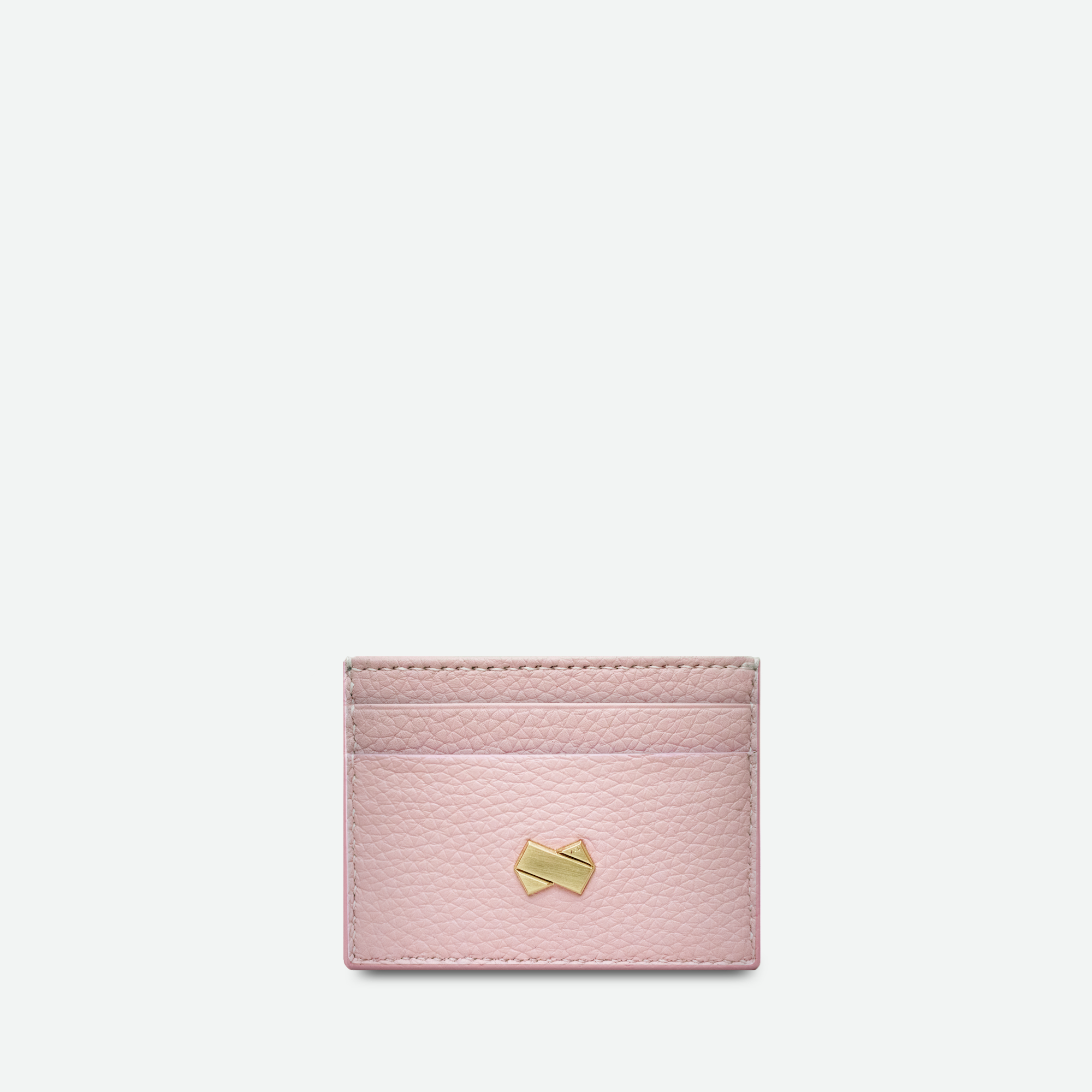 Forside af den lyserøde kortholder i præget læder med forgyldt Faubret-logo.