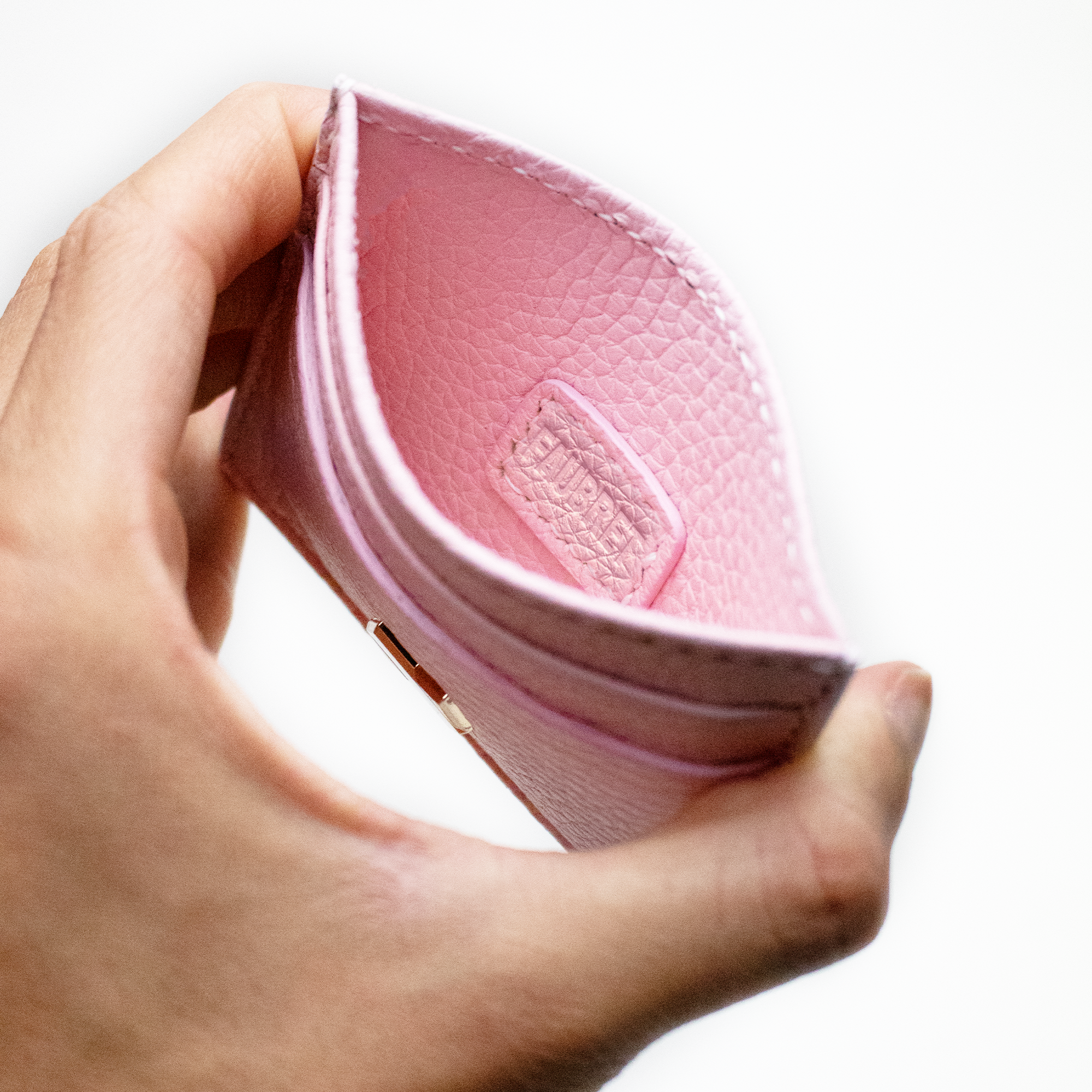 Indersiden af den lyserøde kortholder i præget læder fra Faubret, håndlavet i Frankrig.