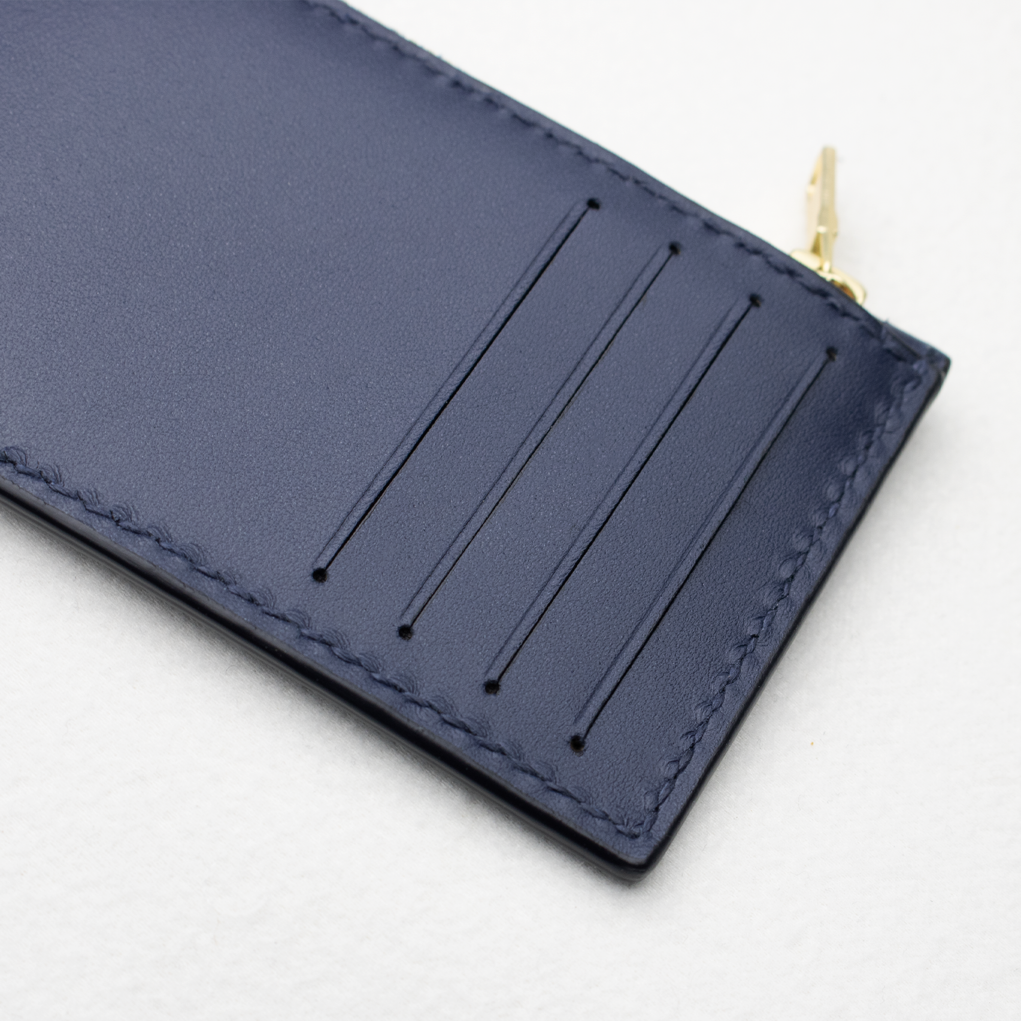 Nærbillede af kortpladserne på Faubret kortholder i blåt læder.