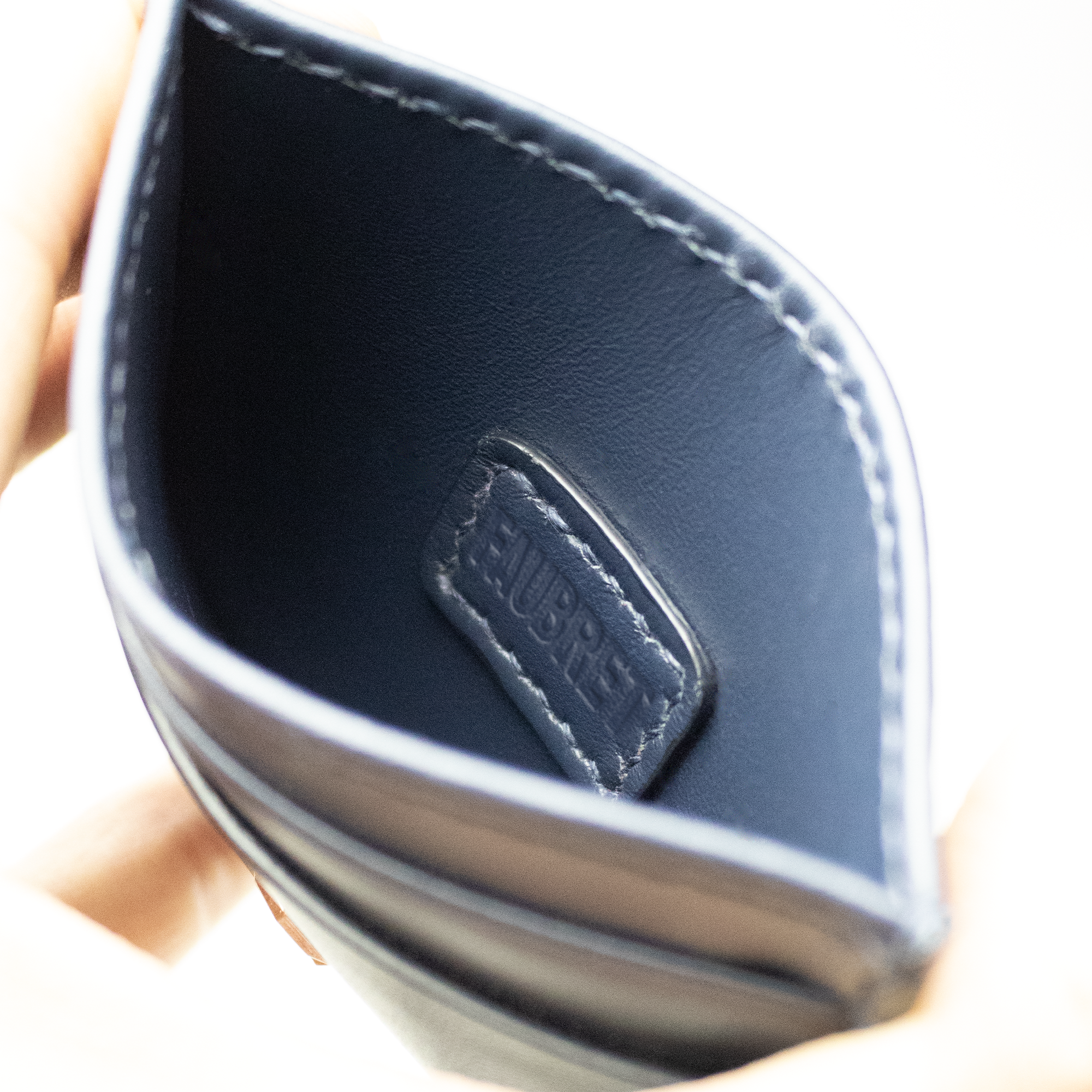 Inderside af Faubret kortholder i navy skind med præget Faubret signatur.